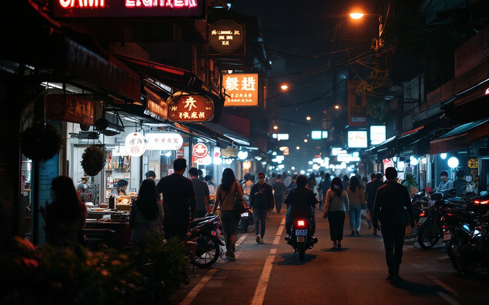 A night street lit by shopfronts, people at distance